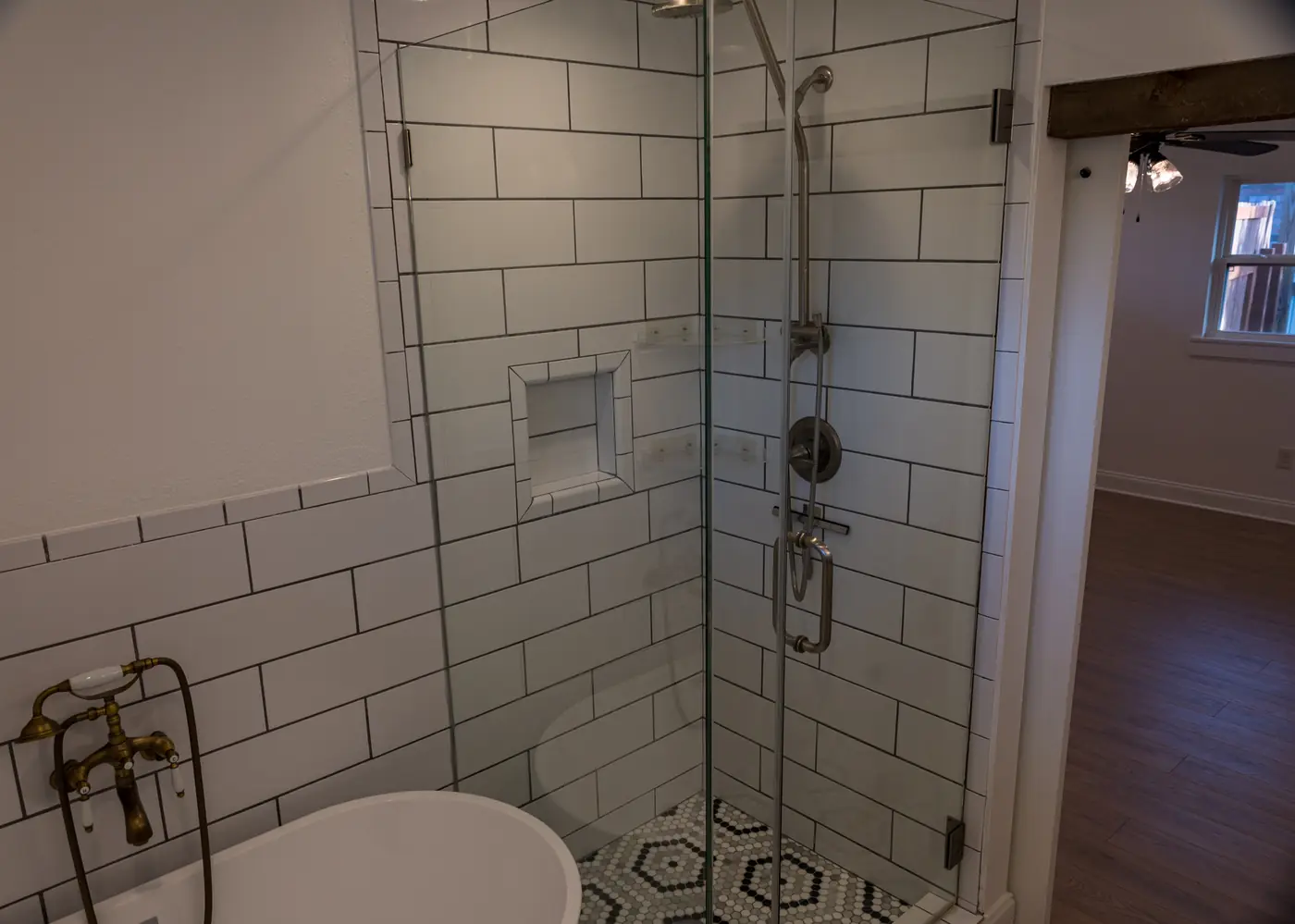Glass walk-in shower with subway tile, a recessed niche and a hex mosaic floor in Metairie, LA