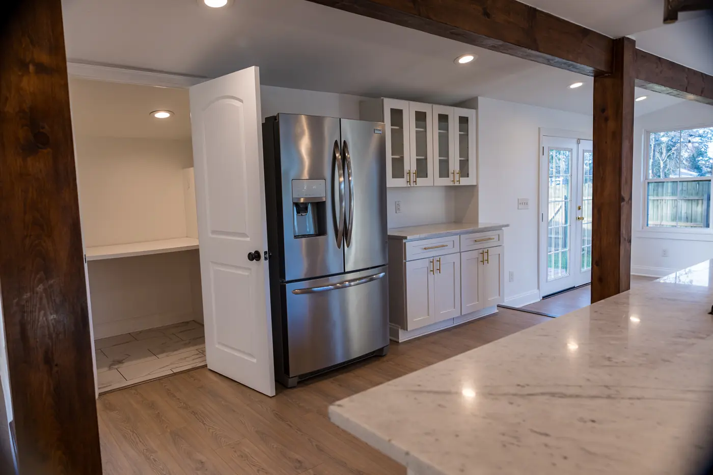 Refrigerator wall and counters Kitchen remodel with a French-door refrigerator, marble-look counters and a wood post in Metairie, LA