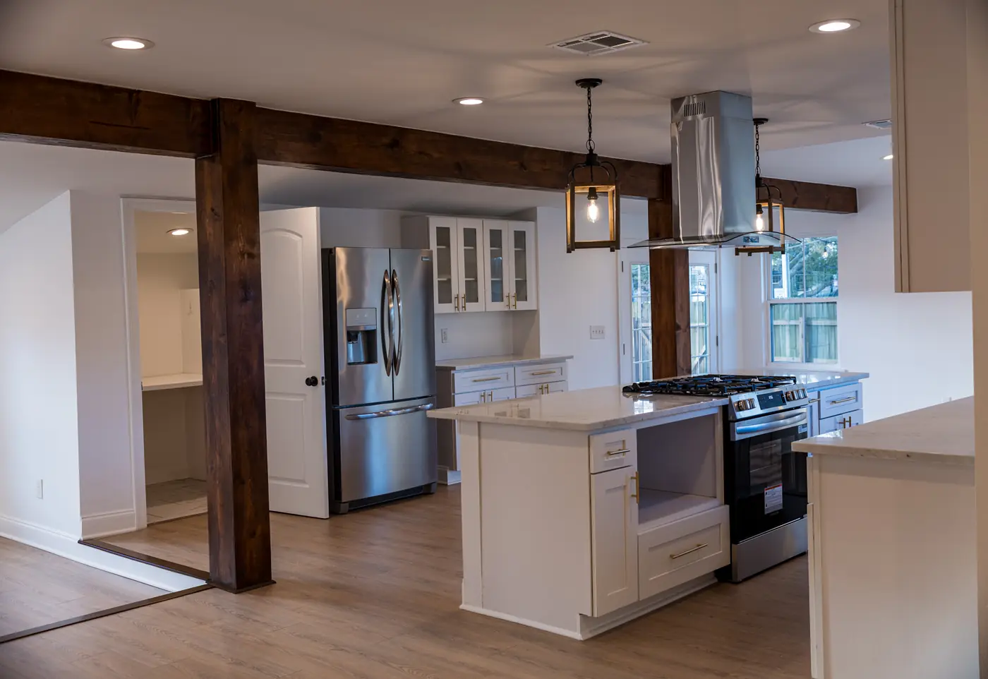 Open kitchen with wood beams Remodeled open kitchen with a white island, stainless range hood and reclaimed wood beams in Metairie, LA