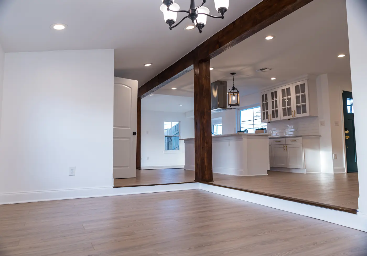 Open living area with beam Opened-up living area with a wood beam and post framing the view into the new kitchen in Metairie, LA