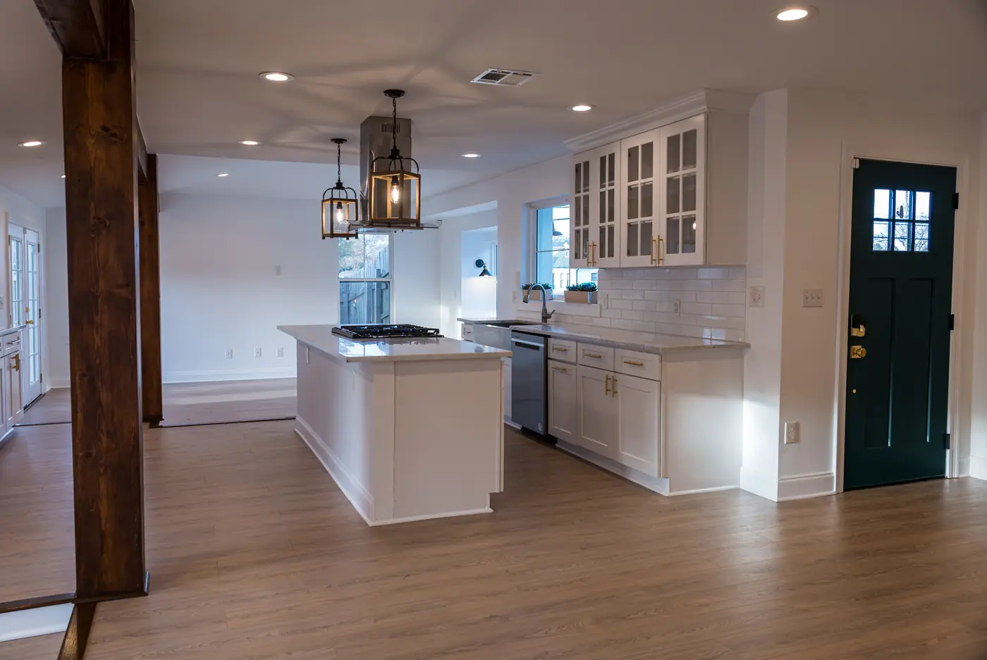 Island with lantern pendants White shaker kitchen island under lantern pendants beside a green front door in Metairie, LA